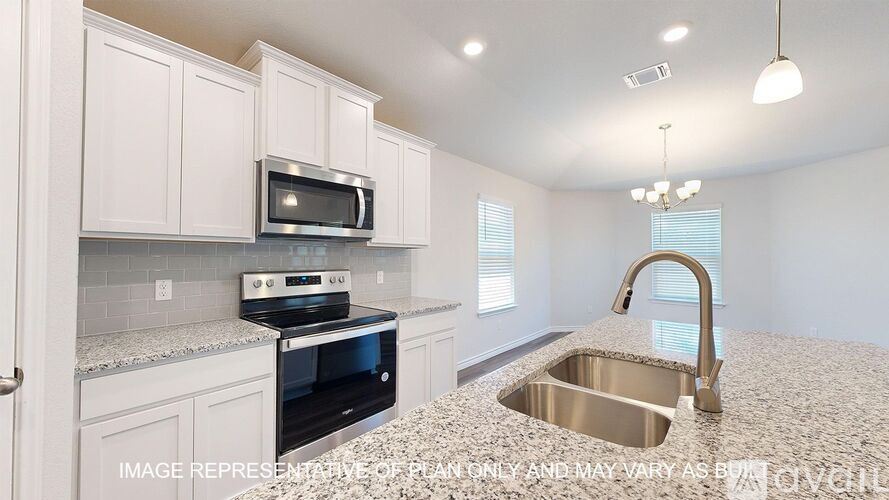 A kitchen with a granite countertop and stainless steel sink.