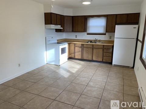 A kitchen with white appliances and wooden cabinets.