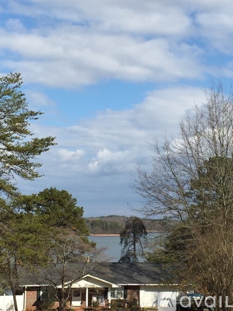 A house with a view of a lake and trees.