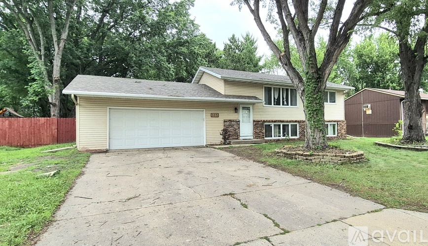 A house with a garage and a driveway in front of it.