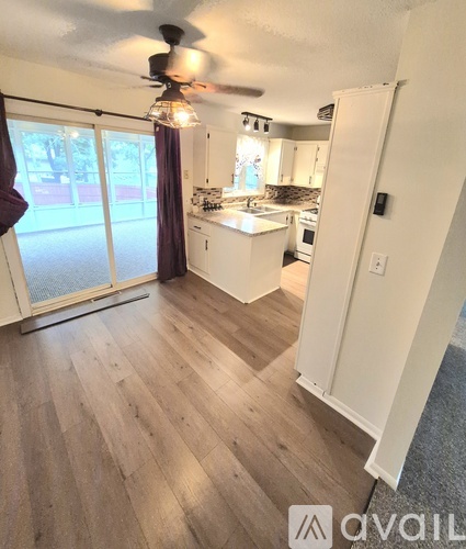 A kitchen with a sliding glass door leading to a backyard.