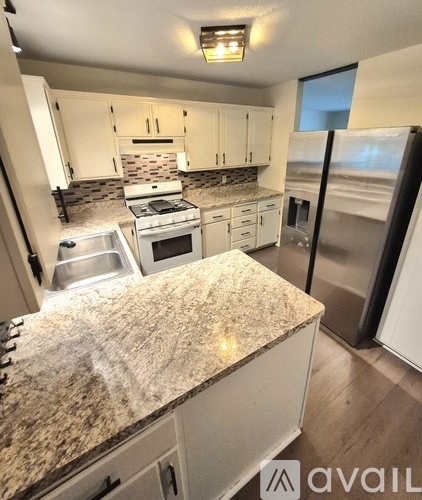 A kitchen with granite countertops and stainless steel appliances.