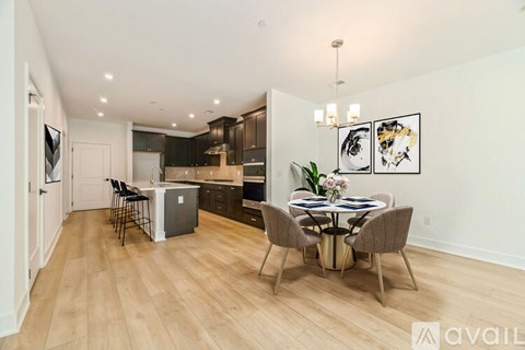 A kitchen with a dining table and chairs in the middle of the room.
