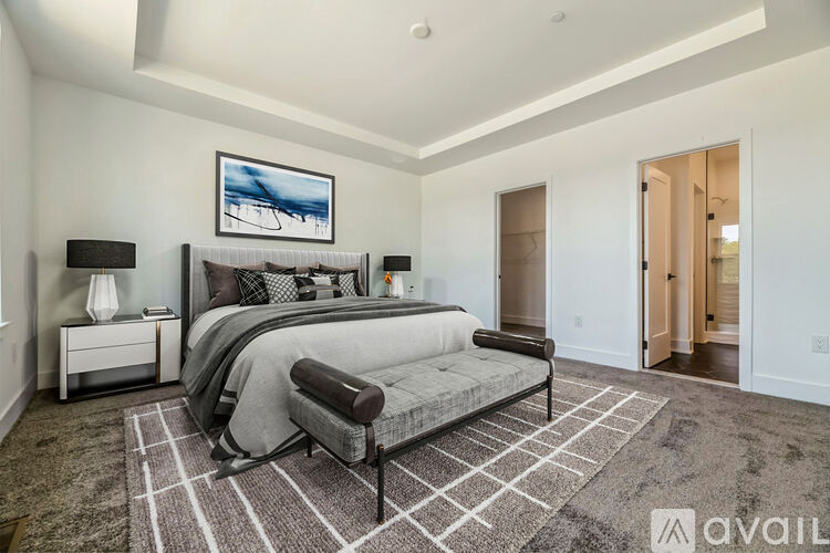 A bedroom with a large bed and a painting on the wall.