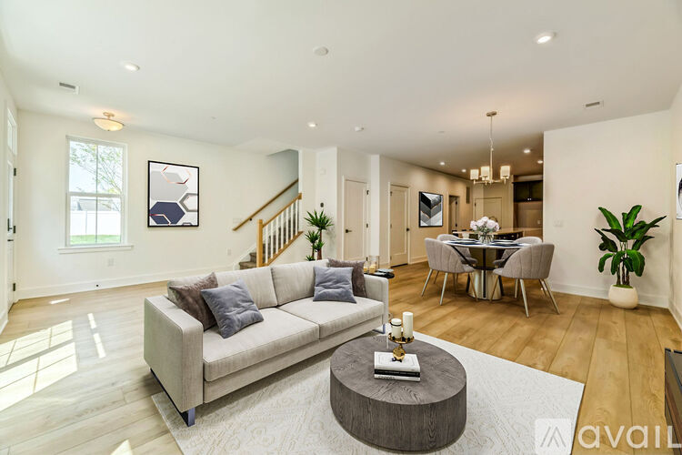 A living room with a couch, a coffee table, and a dining table.