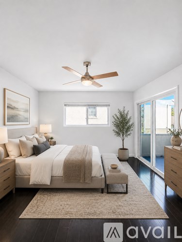 A bedroom with a large bed and a ceiling fan.