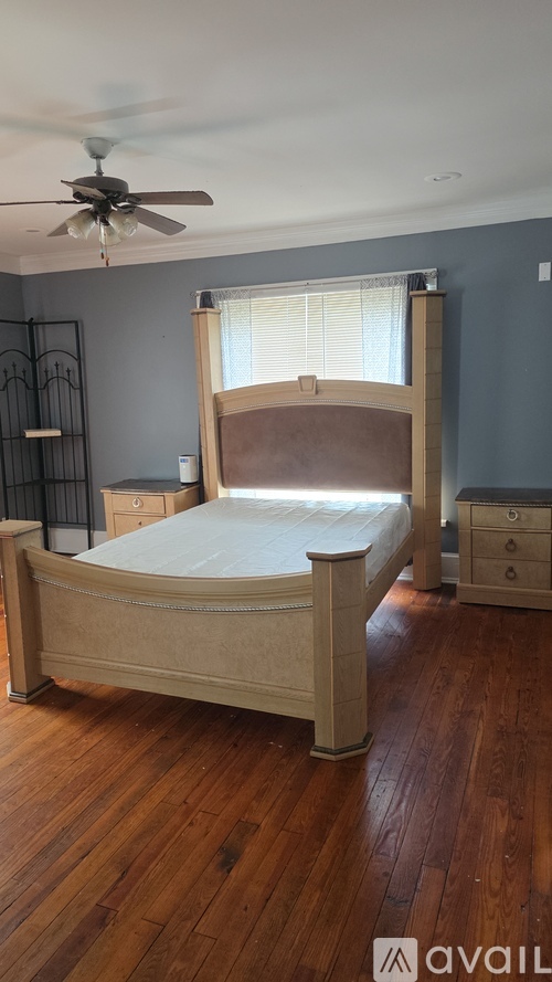 A bedroom with a bed, dresser, and ceiling fan.