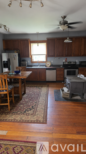 A kitchen with wooden cabinets and a rug on the floor.
