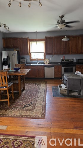 A kitchen with wooden cabinets and a rug on the floor.