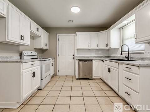 A kitchen with white cabinets and appliances.