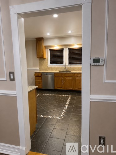 A kitchen with wooden cabinets and a tile floor.