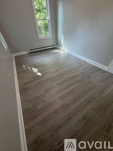 A room with wooden flooring and a window.