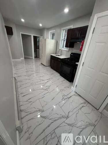 A kitchen with marble flooring and white walls.