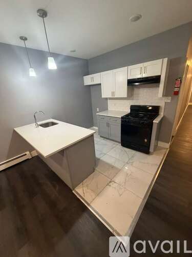 A kitchen with a white countertop and black appliances.