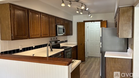 A kitchen with wooden cabinets and a white countertop.