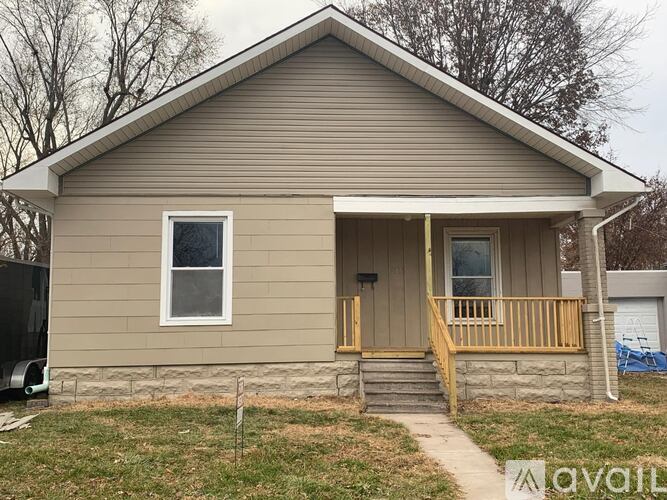A small house with a porch and a covered patio.