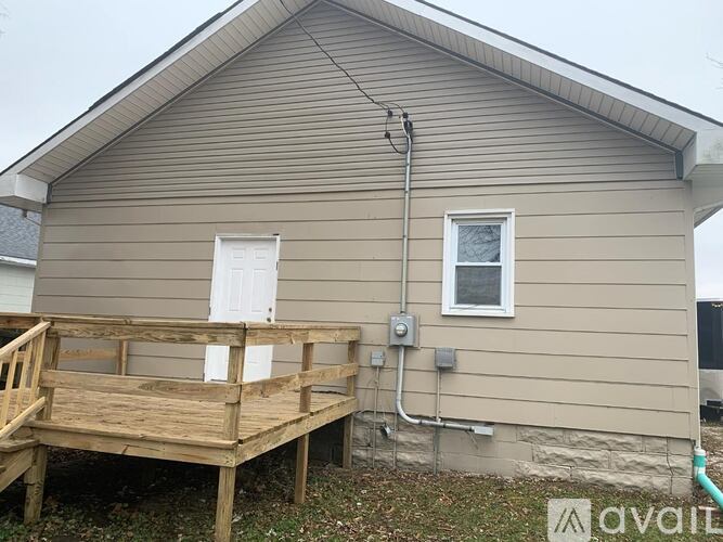 A house with a deck and a satellite dish on the roof.