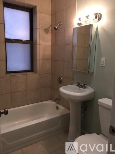 A bathroom with a white tub, sink, and toilet.