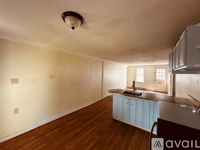 A kitchen with wooden floors and a blue cabinet.