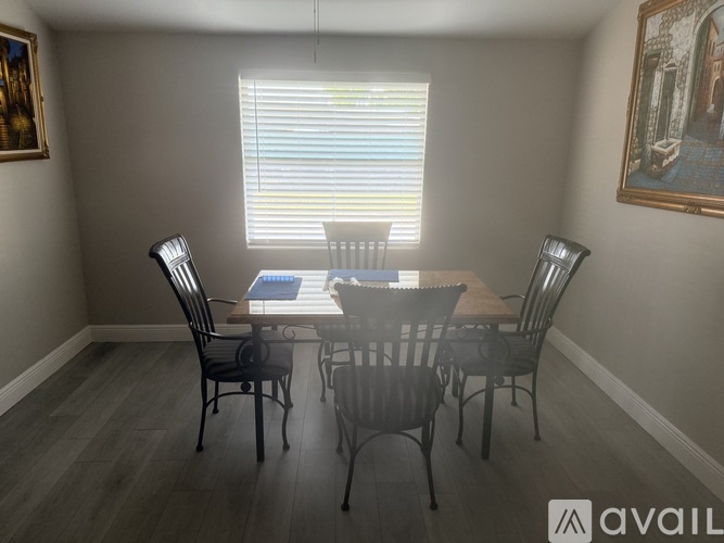 A dining room with a table and chairs.