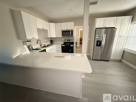 A modern kitchen with white cabinets and appliances.