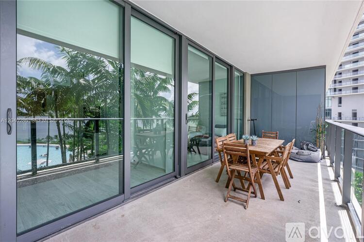 A patio with a table and chairs overlooks a pool.