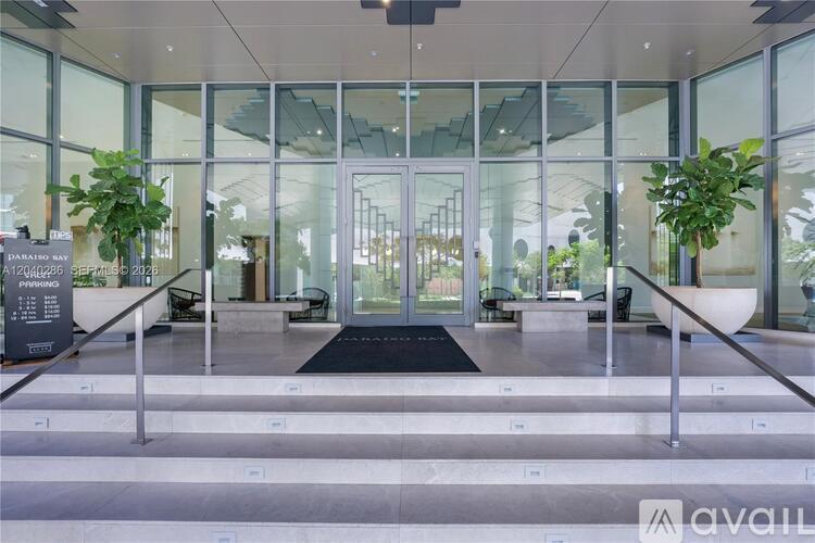 A glass door entrance with a black mat in front.
