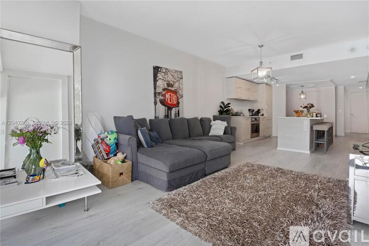 A living room with a grey sofa and a white coffee table.