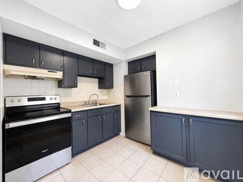 A kitchen with black cabinets and stainless steel appliances.