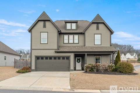 A two-story house with a garage and a driveway.