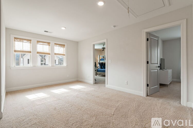 A spacious room with a carpeted floor and a large window.