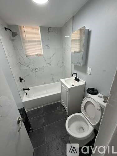 A bathroom with a toilet, sink, and bathtub.