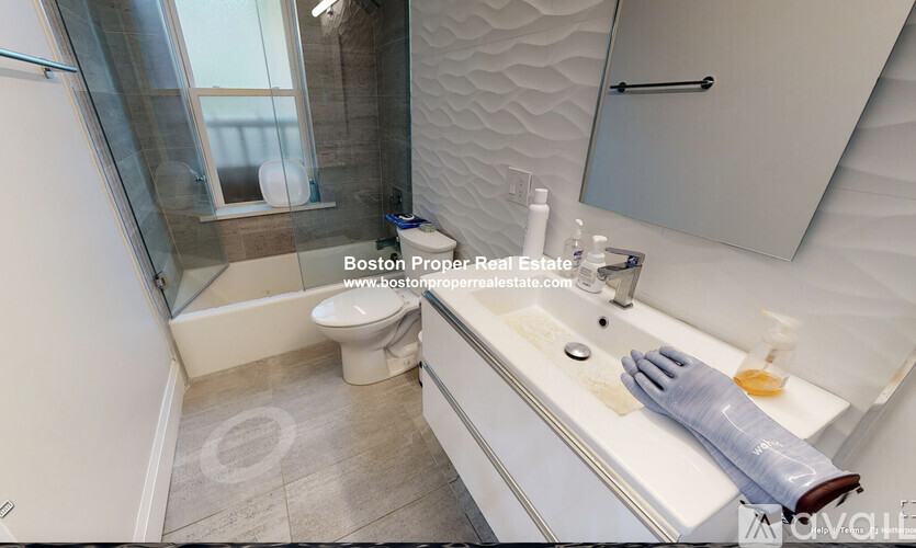 A bathroom with a toilet, sink, and a window.