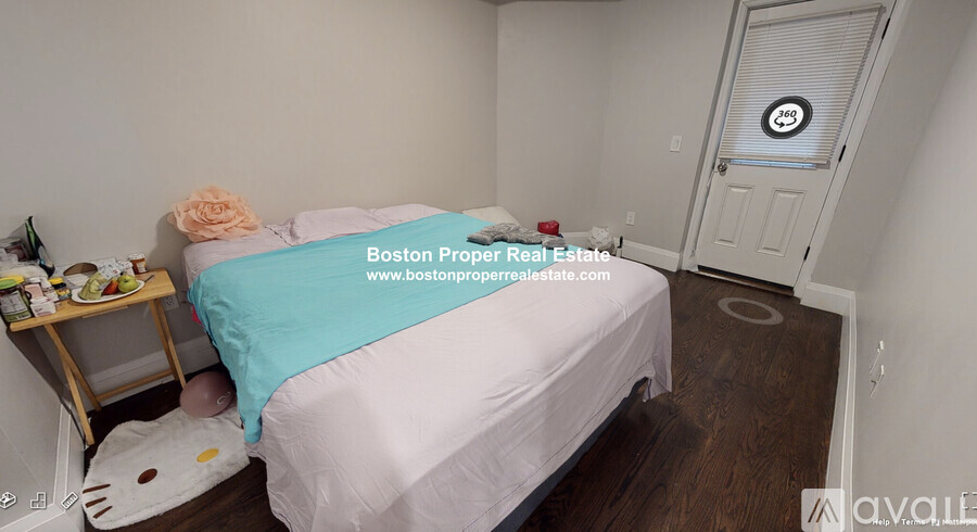 A bedroom with a bed, nightstand, and a cat bed.