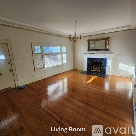 A living room with wood floors and a fireplace.