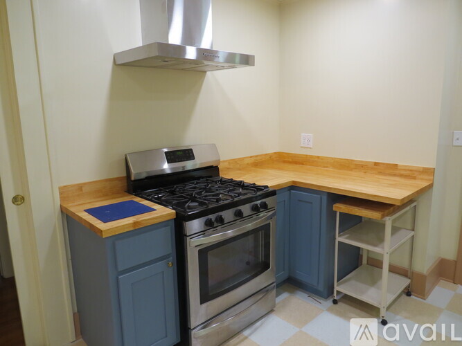 A kitchen with a stove top oven and a stainless steel range hood.
