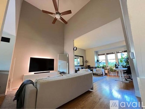 A living room with a white couch and a flat screen TV.