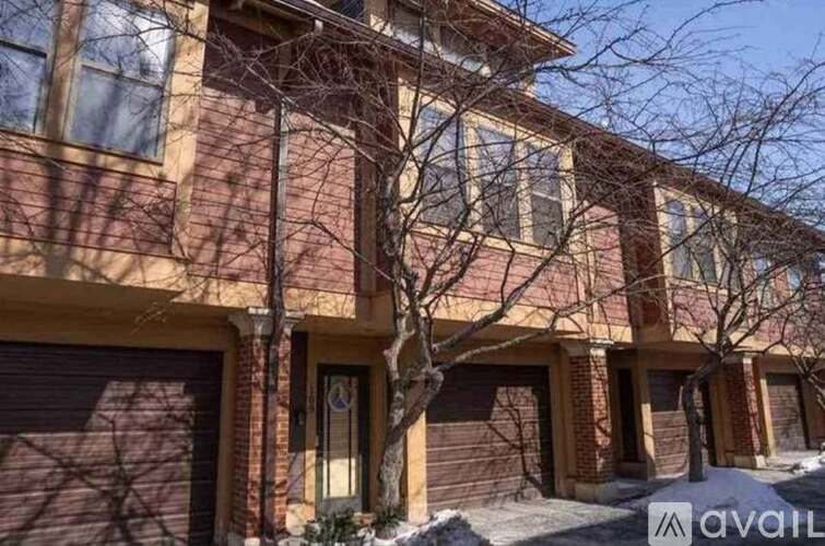 A brown brick building with a tree in front of it.