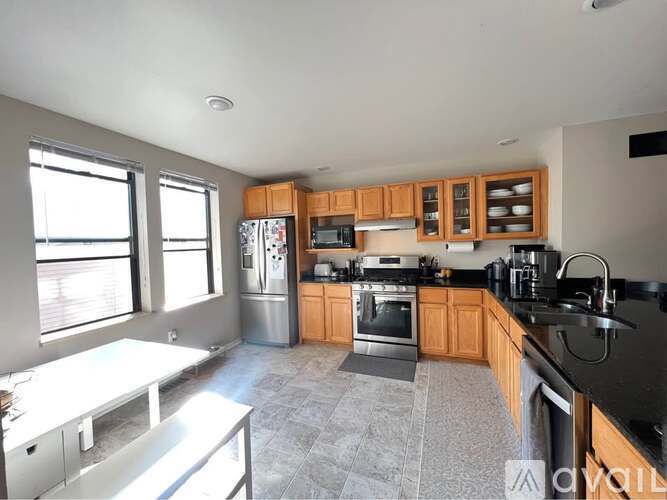 A kitchen with wooden cabinets and black countertops.