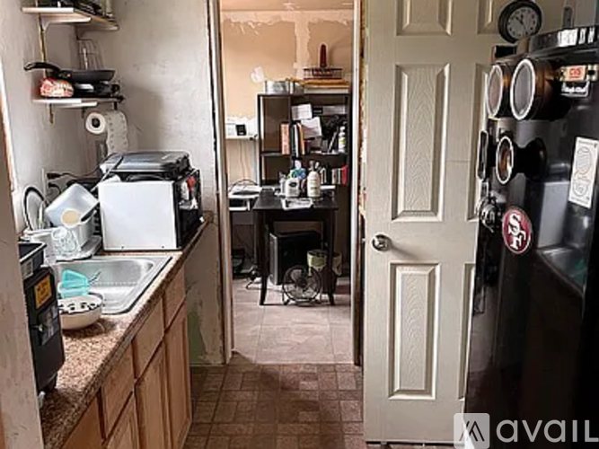 A kitchen with a black fridge and a white door.
