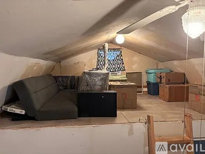 A living room with a grey couch and a black box on the floor.