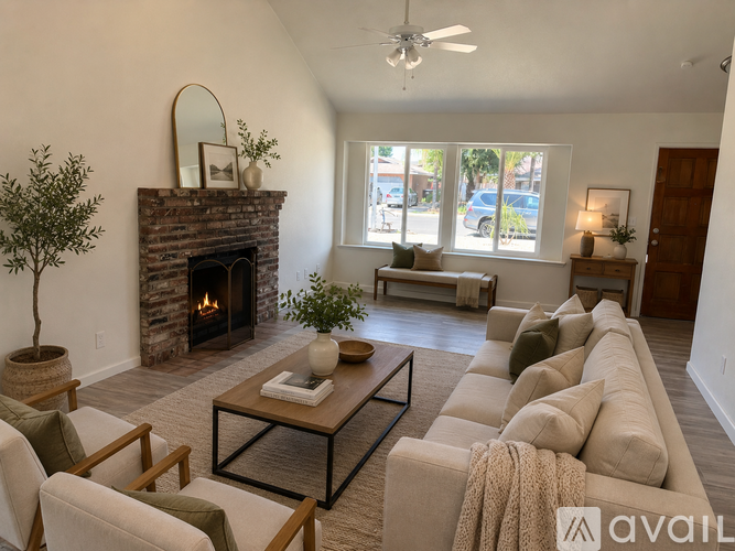A spacious room with a fireplace and a ceiling fan.