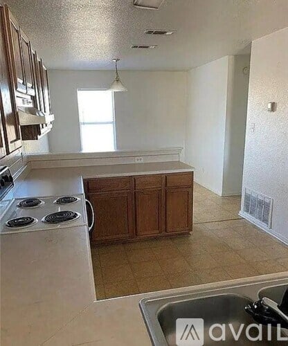 A kitchen with a stove top oven and a sink.