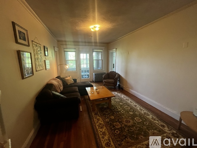 A living room with a couch, coffee table, and pictures on the wall.
