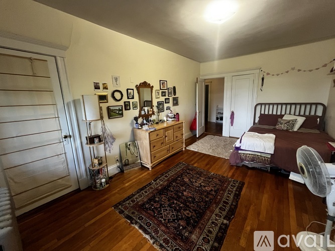 A bedroom with a bed, dresser, and a rug.