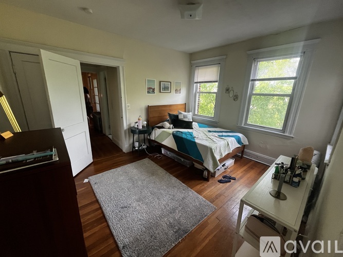 A bedroom with a bed, a dresser, and a window.