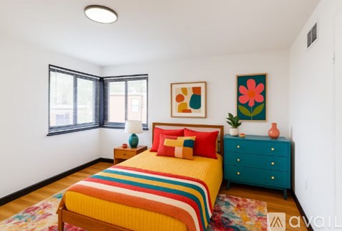 A bedroom with a bed, nightstand, and a painting on the wall.