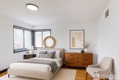 A bedroom with a bed, a chair, and a dresser.