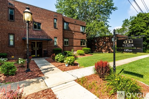 A brick building with a sign that says "LUXOR Office".