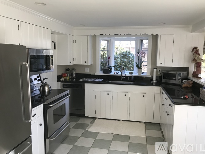 A kitchen with black countertops and white cabinets.